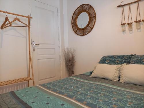 a bedroom with a bed and a mirror on the wall at Le carpe diem, appt à 10 min de Nîmes in Bouillargues