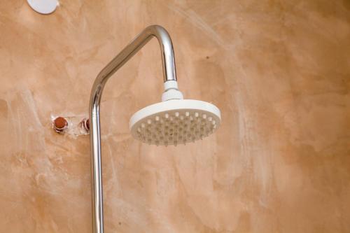 a shower with a shower head in a bathroom at Mikoko Beach & Cottages in Bagamoyo