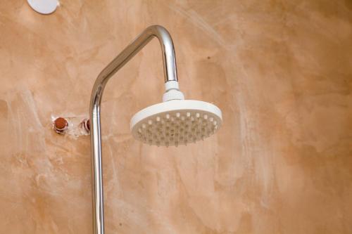 La salle de bains est pourvue d'une douche avec un pommeau de douche. dans l'établissement Mikoko Beach & Cottages, à Bagamoyo