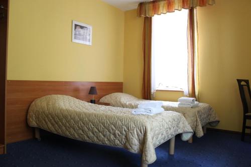 pokój hotelowy z 2 łóżkami i oknem w obiekcie Hotel Pod Jeleniem w Tucholi