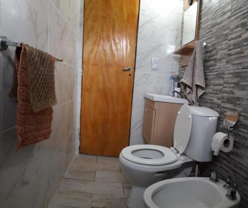 a bathroom with a white toilet and a sink at casa ana y teo in Mar del Plata