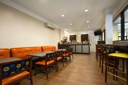 a restaurant with tables and chairs and a kitchen at Days Inn by Wyndham Fultondale in Fultondale