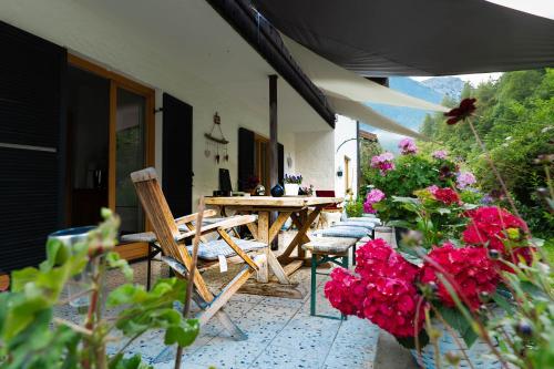 a patio with a table and chairs and flowers at Engelsherz in Mittenwald