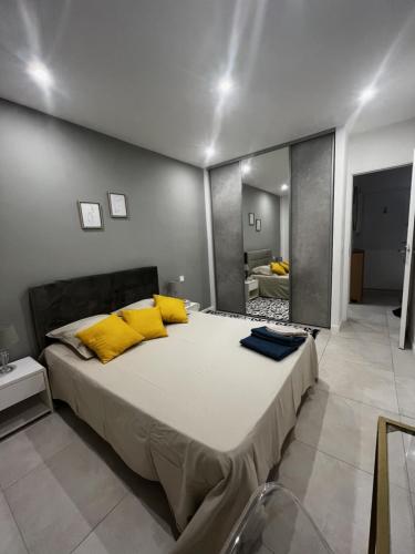 une chambre avec un grand lit avec des oreillers jaunes dans l'établissement Superbe Appartement Hypercentre climatisé, à Cannes