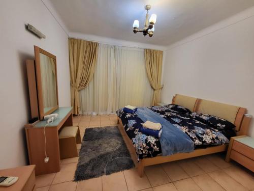 een slaapkamer met een bed, een bureau en een spiegel bij Luxury & stylish Naama bay flat at the centre of Sharm in Sharm El Sheikh
