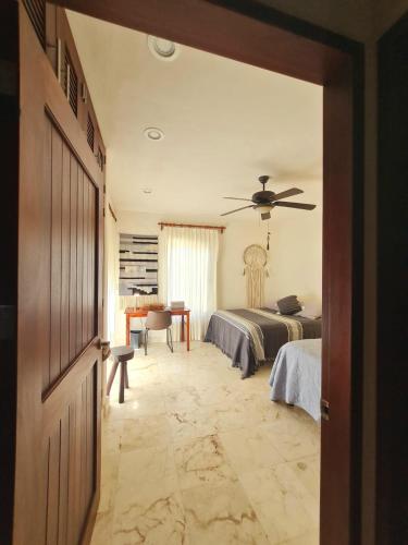 a bedroom with two beds and a ceiling fan at STYLISH OCEANFRONT CONDO with POOL in Mahahual