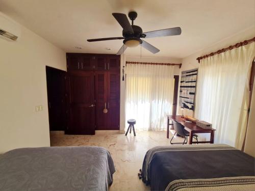 a bedroom with two beds and a ceiling fan at STYLISH OCEANFRONT CONDO with POOL in Mahahual
