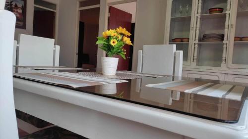 a dining room table with a vase of flowers on it at Apartamento Turistico Centenario in Montenegro