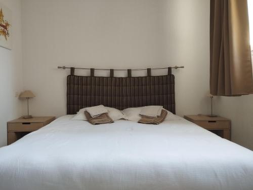 1 dormitorio con 1 cama blanca y 2 toallas en Appartement 2 Pièces Le Domaine de Manon, en Signes