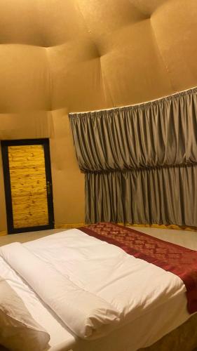 a bedroom with a large bed with a window at Syndebad desert camp in Wadi Rum
