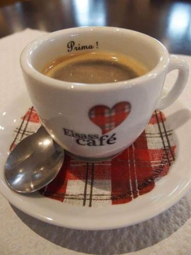 a cup of coffee on a plate with a spoon at Gîte Le 1602 in Saint-Nabor