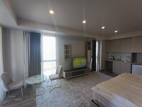 a bedroom with a bed and a table and a tv at Avenue guest in Büyükçekmece