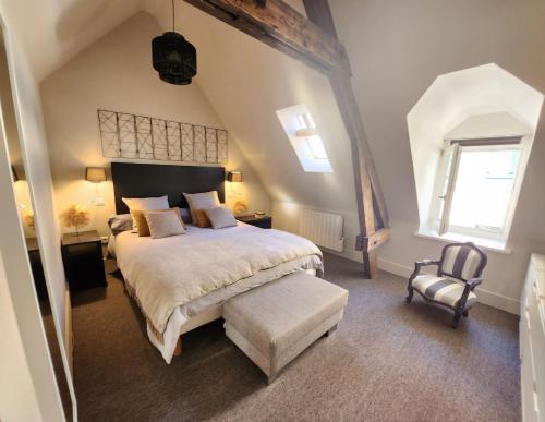 una camera con un grande letto e una sedia di Gite Boulogne-sur-mer a Boulogne-sur-Mer