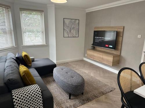 a living room with a couch and a tv at Premium executive Apartment in Dunfermline in Dunfermline