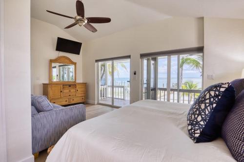 a bedroom with a bed and a ceiling fan at BEACHFRONT-Amazing Fishing,Shelling,Sunrise views! in Captiva