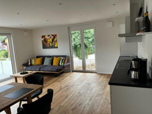 a kitchen and living room with a couch and a table at Müller s Ferienhäusle UG in Vogtsburg