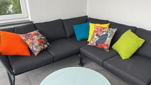 a black couch with colorful pillows on it at Müller s Ferienhäusle UG in Vogtsburg