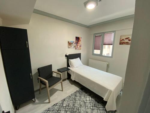 a small bedroom with a bed and a chair at Eraliz in Buca