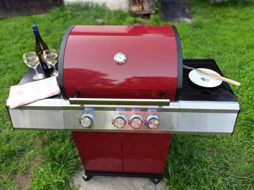 a red grill with wine glasses and a bottle of wine at Chata Koza in Bublava