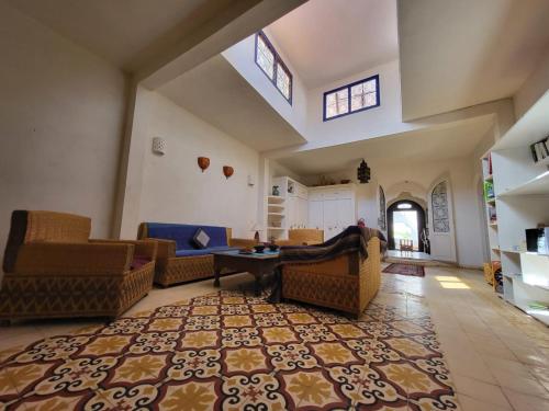 a large living room with couches and a rug at Dar Janoub in Beni Balla
