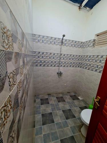 a bathroom with a toilet and a shower at GKAT Resort in Mbarara