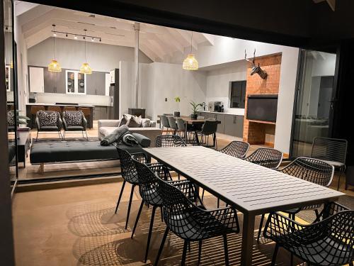 a dining room and living room with a table and chairs at Highland Gate Range View in Dullstroom
