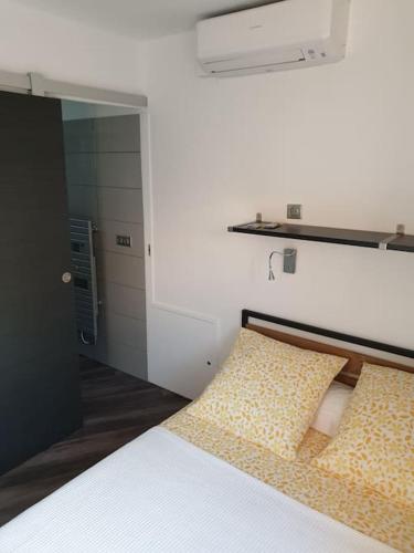 Cette chambre blanche dispose d'un lit avec un mur blanc. dans l'établissement F2 tout confort avec vue panoramique, à Bastelicaccia