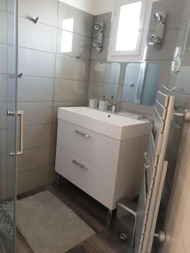 La salle de bains est pourvue d'un lavabo et d'un miroir. dans l'établissement F2 tout confort avec vue panoramique, à Bastelicaccia