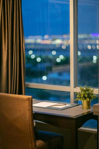 a desk in a room with a window and a desk with a chair at Siam Mandarina Hotel - Free BKK Airport Shuttle in Lat Krabang
