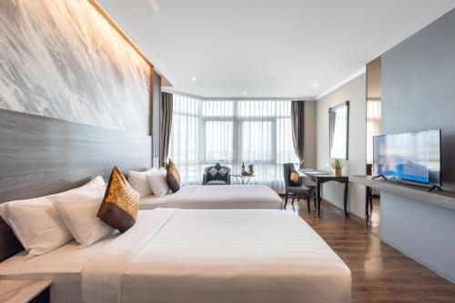 ラートクラバンにあるSiam Mandarina Hotel - Free BKK Airport Shuttleのベッド2台、薄型テレビが備わるホテルルームです。
