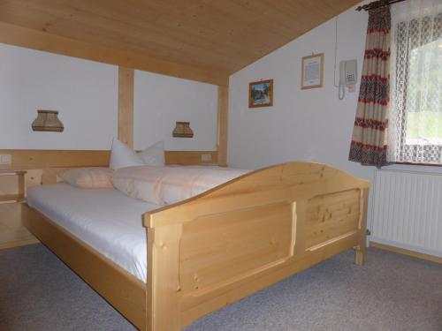 a bedroom with a wooden bed in a room at Ferienhaus Tirolerhof in Kals am Großglockner