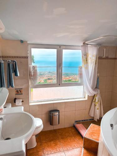 a bathroom with a tub and a sink and a window at Sun-soaked apt w patio, balcony & garden - Aguilas in La Orotava