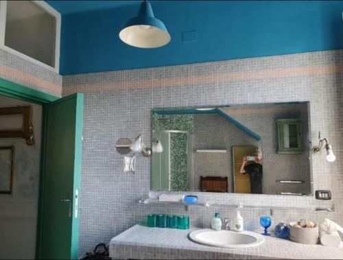 La salle de bains est pourvue d'un lavabo et d'un grand miroir. dans l'établissement Villa Eclettica A POCHI METRI DAL MARE, à Pesaro