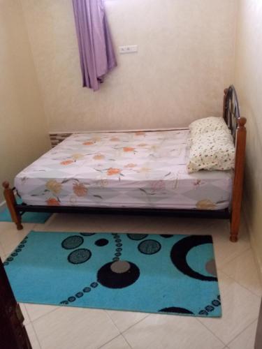 a small bed in a room with a rug at شقة فونتي العليا in Agadir