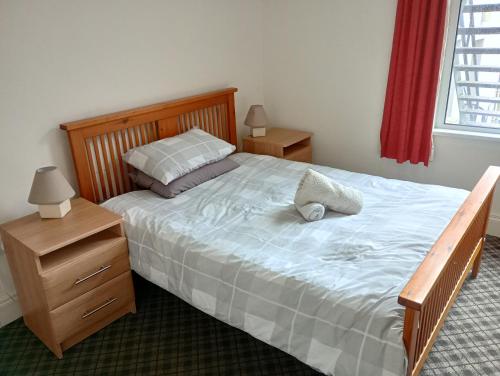 una camera con un grande letto con testiera in legno di Eglantine Townhouse a Belfast