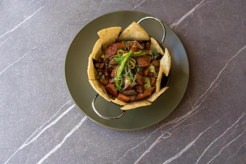 a green plate with a taco with meat and vegetables at Lady Mom Hostal in Medellín