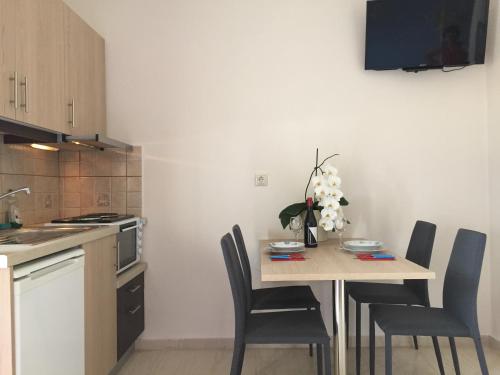 a kitchen with a wooden table with chairs and a table sidx sidx sidx at Apollon Hotel in Sitia