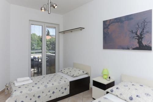 a bedroom with two twin beds and a window at Dubrovnik Summer Apartments in Dubrovnik