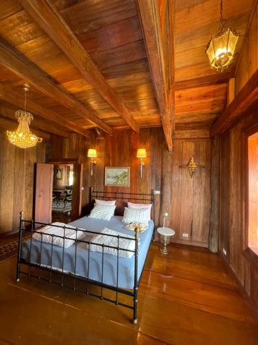um quarto com uma cama num quarto com paredes de madeira em WoodHouse Homestay Chiangrai 
