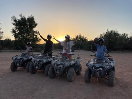a group of people riding atvs on a dirt field at Aghmat Lodge Guest house in Marrakech