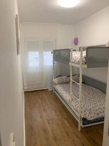 - une chambre avec 2 lits superposés et du parquet dans l'établissement Coqueto apartamento en Gijon, à Gijón