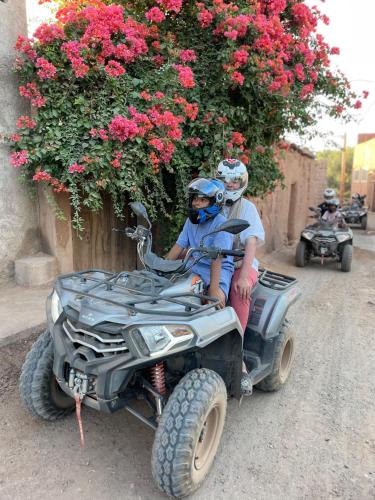 two people riding on a four wheeled vehicle at Aghmat Lodge Guest house in Marrakech