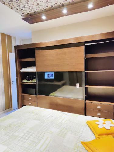 um quarto com uma cama e um grande armário de madeira em Casa aconchegante. em Campo Grande