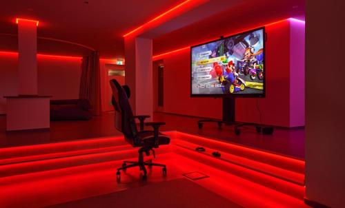a room with a tv in a room with red lights at Hotel Schönbuch in Pliezhausen