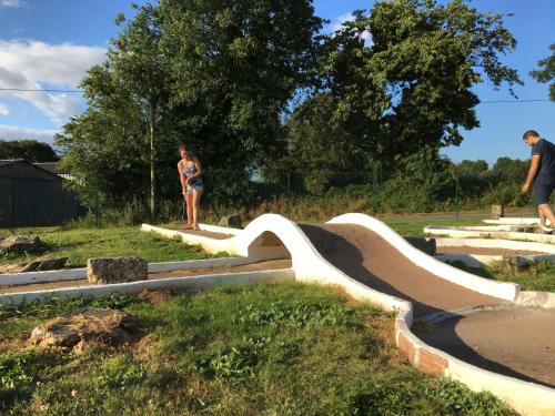 a woman is standing next to a skateboard ramp at La Frouardière, 3 gîtes de charme in Antigny