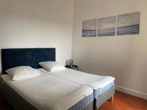 a bedroom with a bed with a blue headboard at UNE TERRASSE SUR LES TOITS in Aix-en-Provence