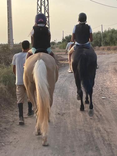 a group of people riding horses down a dirt road at Aghmat Lodge Guest house in Marrakech