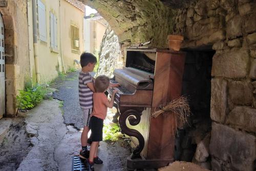two young boys standing next to an old piano at Champeix, maison confort 6 personnes in Champeix