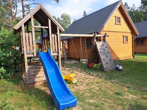 a playground with a slide and a house at Lesne Runo Borsk in Borsk