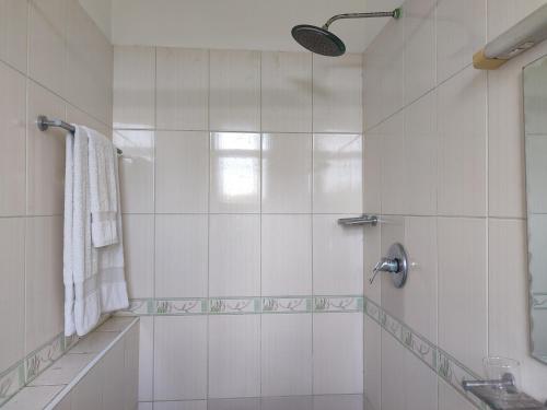 a white bathroom with a shower and a sink at Shikara Apartment in Mombasa